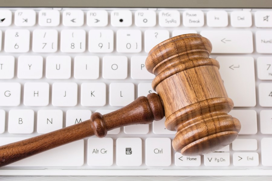 Auctioneer's gavel resting on a computer keyboard representing online auctions